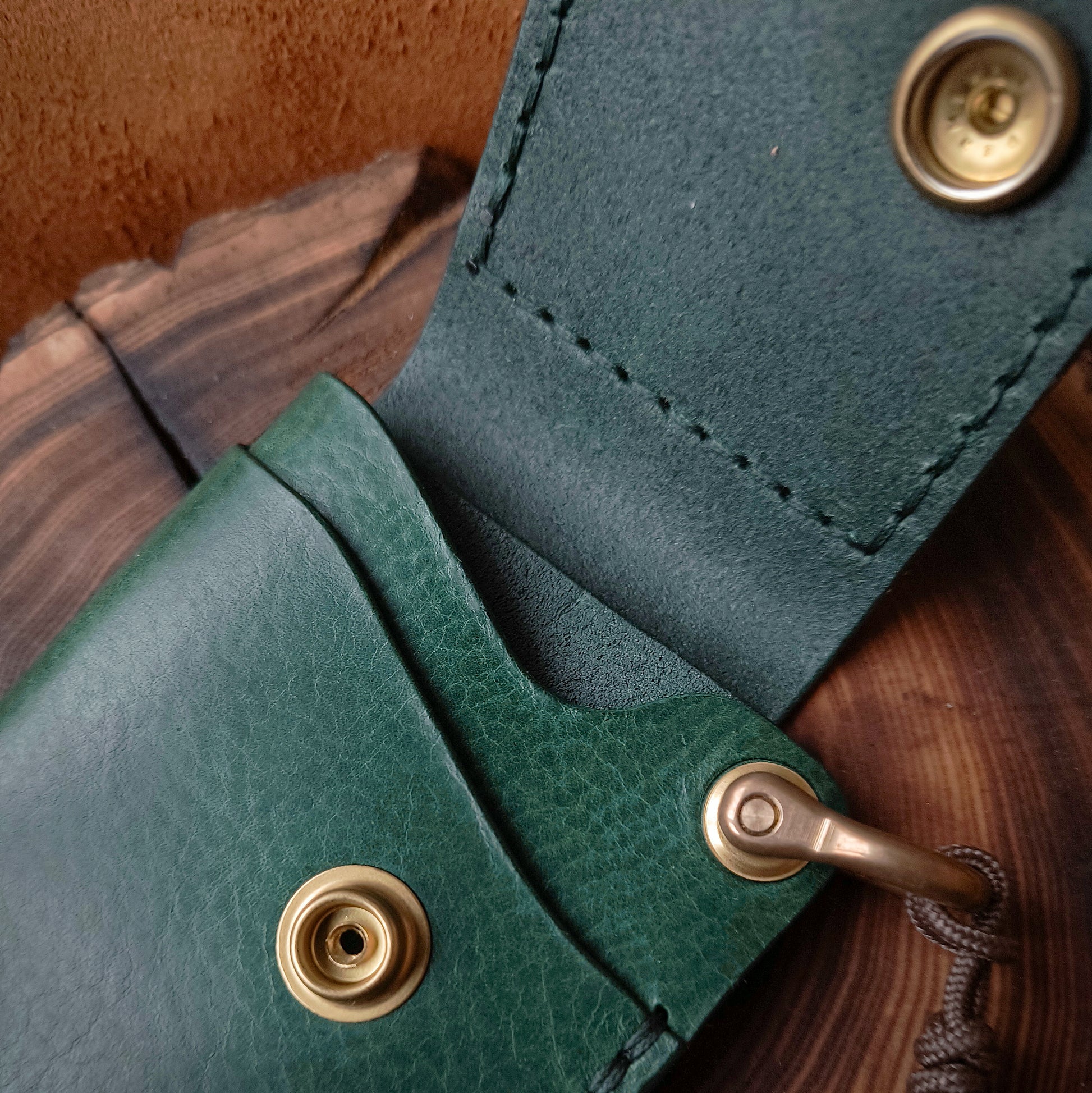 Compact handmade wallet made from premium quality full-grain textured leather in rich emerald green colour and fully solid brass hardware 
